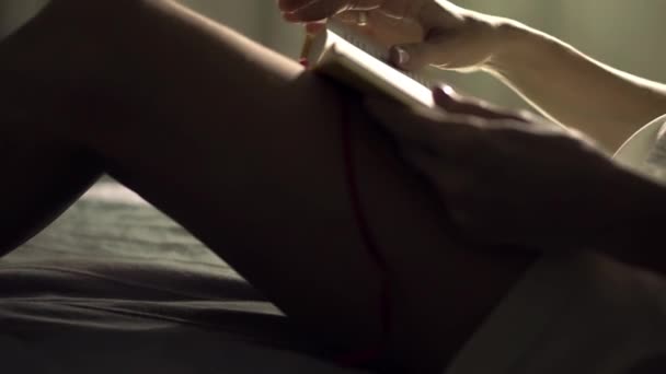 Unerkennbares Mädchen liest nachts ein Buch in ihrem Bett — Stockvideo