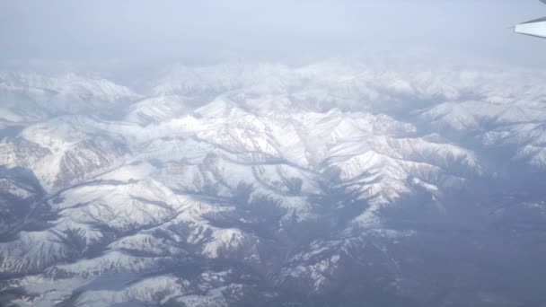 Výhled z okénka dopravní letadlo s zasněžených hor — Stock video