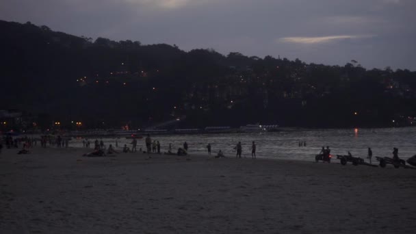 Phuket Patong beach på kvällen med silhuetter av människor — Stockvideo