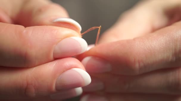 Enfiler une aiguille avec un fil orange. Macro vidéo avec mise au point racking — Video