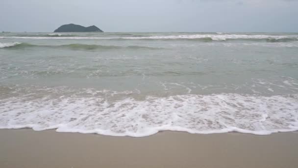 Surf e isla distante en el horizonte. Vídeo en cámara lenta filmado en día nublado — Vídeos de Stock