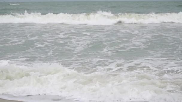 Видео медленного движения пенного морского серфинга на песчаном пляже — стоковое видео