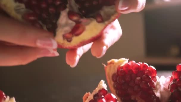 Young woman breaking a piece of pomegranate — Stock Video