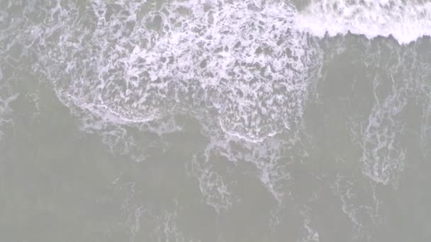 Tapas blancas en las olas del mar, vista aérea desde arriba. Vídeo en cámara lenta — Vídeo de stock