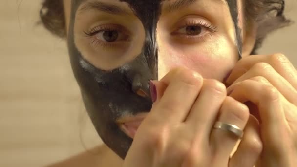 Vacker kvinna att ta bort elastisk svart Face Pack från hennes ansikte — Stockvideo