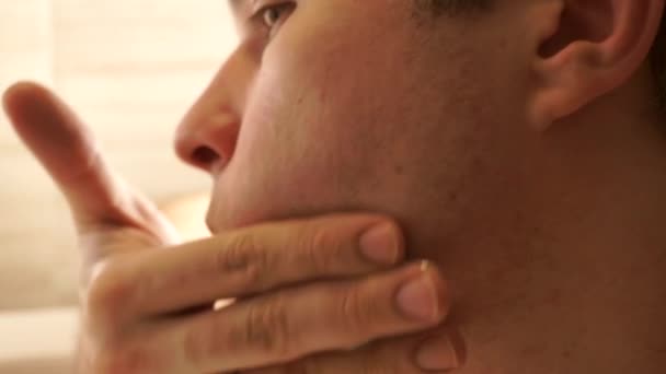 Joven hombre guapo usando su bálsamo después del afeitado, perfil de cerca de vídeo — Vídeo de stock