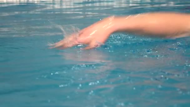 Young handsome man swims in the swimming pool. Close up slow motion shot — Stockvideo