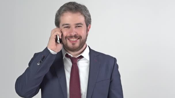 Empresario en traje con corbata sonriendo y hablando por teléfono — Vídeos de Stock