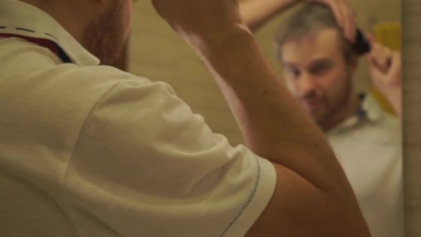 Ένας άνθρωπος βούρτσισμα τα μαλλιά στο μπάνιο — Αρχείο Βίντεο