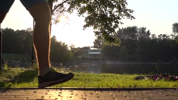 Медленное движение устойчивый клип на закат парк и бегун входящих и выходящих кадров — стоковое видео