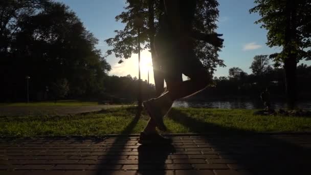 Super câmera lenta clipe steadicam de corredor masculino silhueta do pôr do sol no parque — Vídeo de Stock