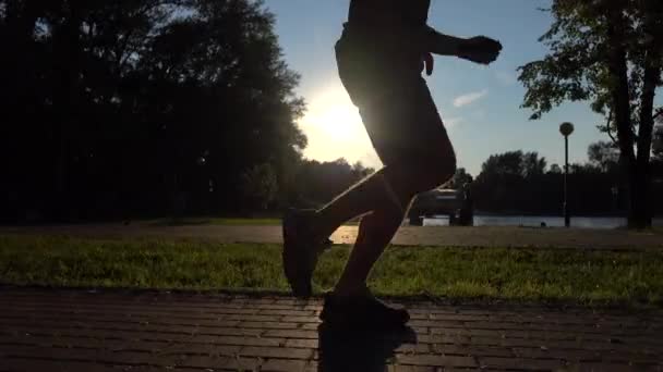 Manliga löpare ben solnedgång siluett. 4 k steadicam video — Stockvideo