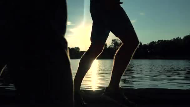 Ο άνθρωπος δρομέας πόδια ηλιοβασίλεμα Σκιαγραφία ενάντια νερό, χρώμα που βαθμολογούνται. 4 k κλιπ steadicam — Αρχείο Βίντεο