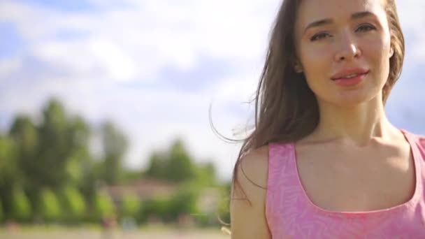 Sorridente ragazza bruna in abito rosa cammina alla fotocamera. Clip steadicam al rallentatore — Video Stock