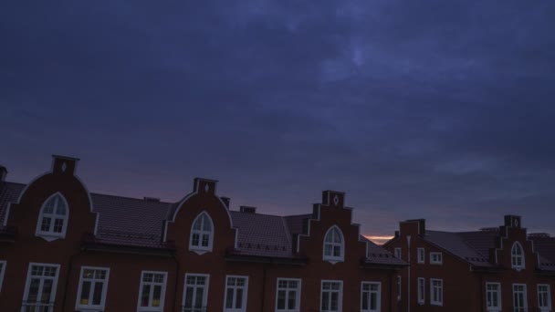 Nubes al atardecer sobre casas de ladrillo rojo, vídeo timelapse — Vídeo de stock