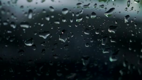 Auto langs achter regenachtige venster. Slow motion bokeh video — Stockvideo