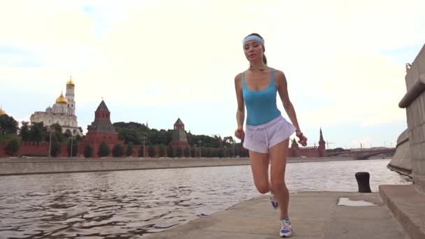 Slow motion steadicam plan d'une fille brune mince coureur contre Moscou Kremlin 240 fps — Video