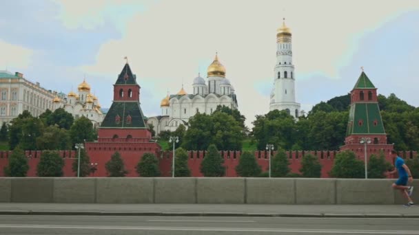 Movimento lento steadicam tiro de um homem de roupas azuis correndo contra Moscou Kremlin 120 fps — Vídeo de Stock