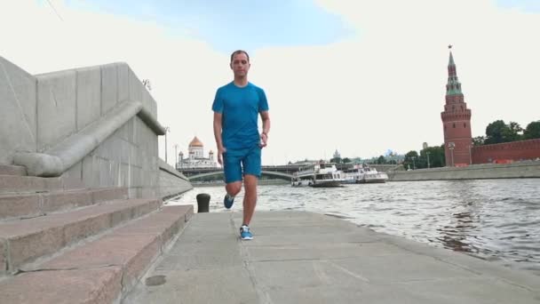 Slow motion steadicam shot of athletic man runner against Moscow Kremlin 120 fps — Stock Video