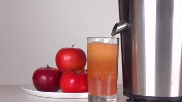 Красный яблочный сок капает из соковыжималки. 4К крупным планом — стоковое видео