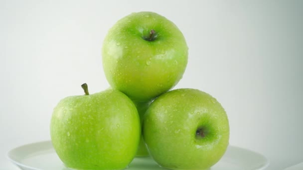 Mano de niña tomando una manzana verde mojada, fondo claro. 4K ProRes cerrar vídeo — Vídeos de Stock