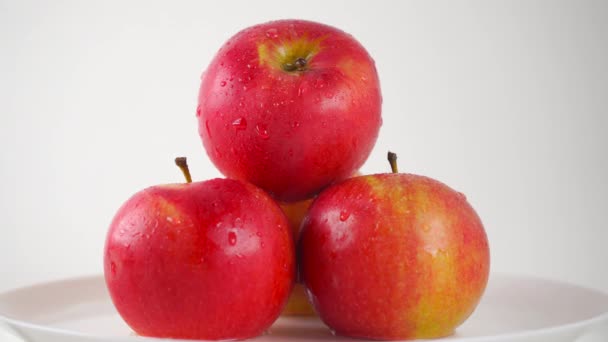 Main de fille prenant une pomme rouge humide, fond clair. Vidéo de gros plan 4K ProRes — Video