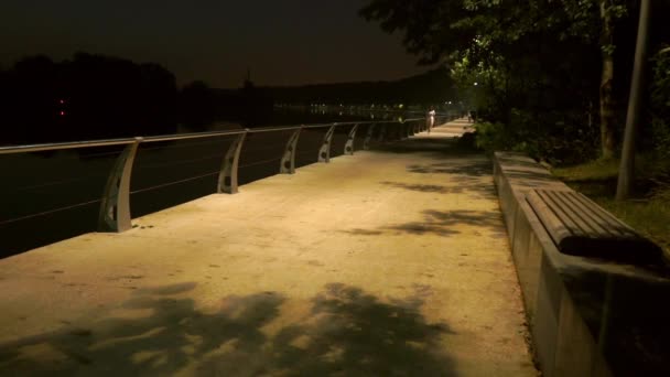 Δύο ποδηλάτες που περνούν από την πάρκο ανάχωμα στο αργά το βράδυ. Αργή κίνηση πυροβολισμό — Αρχείο Βίντεο