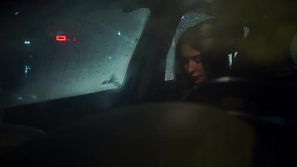 Menina morena bonita atrás da janela do carro na noite chuvosa — Vídeo de Stock