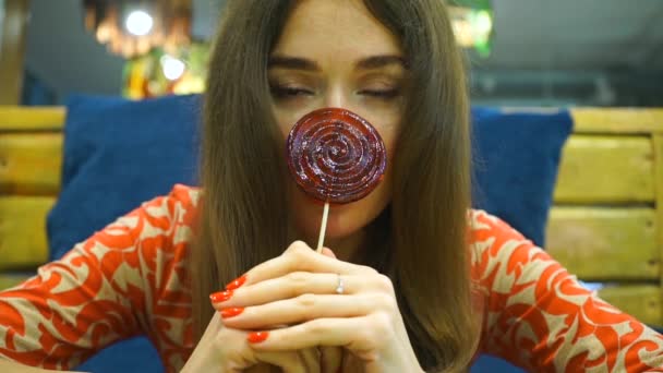 Brunett tjej anläggning röda lollipop — Stockvideo