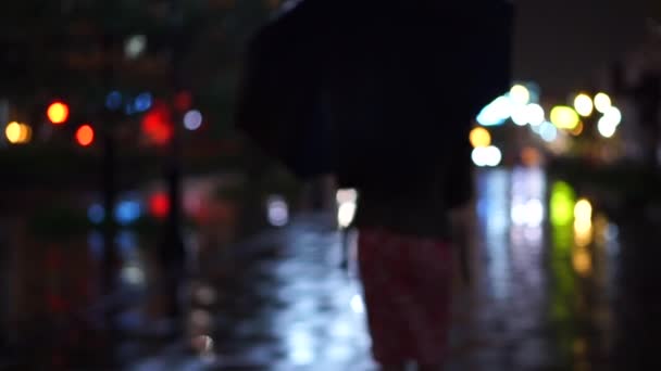 Meisje met paraplu wandelen op regenachtige avond, bokeh video — Stockvideo