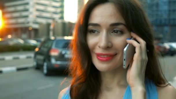 Retrato de una morena feliz hablando en su smartphone en la calle. Super cámara lenta, 250 fps — Vídeos de Stock