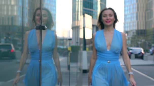 Fille brune joyeuse en robe bleue marchant vers la caméra dans la rue, plan super slow motion, 250 images par seconde — Video