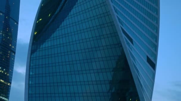 Ljus i office windows i modern skyskrapa. Zooma in 4k upprätta skott — Stockvideo