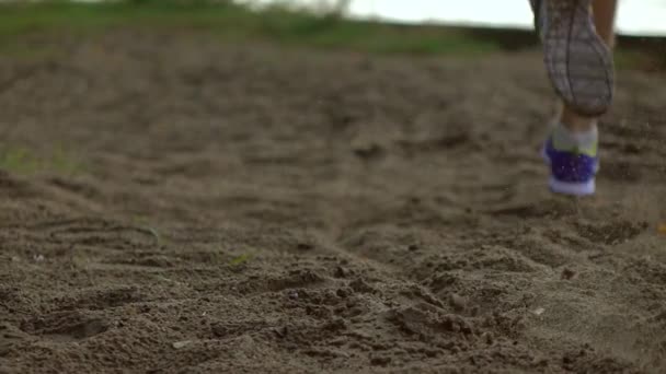 Super Zeitlupe Steadicam Aufnahme von verschwommenen Läuferbeinen und fliegendem Schmutz. Sandstrand, Teleobjektiv — Stockvideo