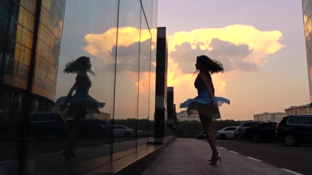 Slanke meisje in jurk spinnen op straat bij zonsondergang, super slow-motion shot — Stockvideo