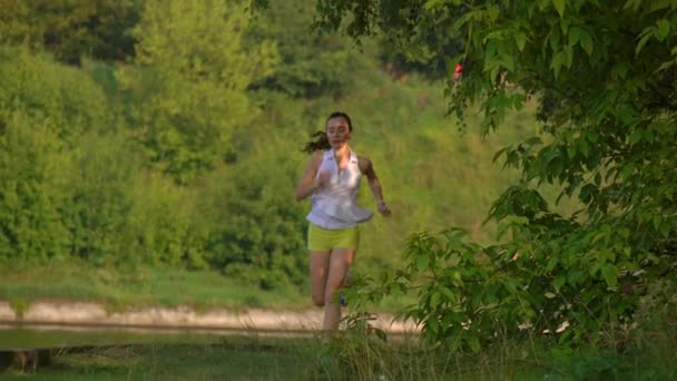 Brunette meisje draait op zanderige zomer langs de rivier. 4 k steadicam uitzoomen schot — Stockvideo