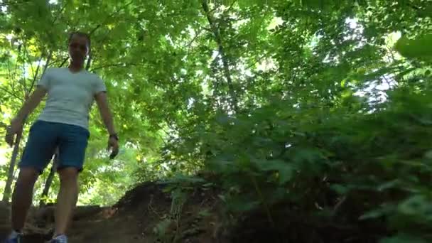 Un uomo che cammina di sotto nel parco. 4K steadicam tracking shot — Video Stock