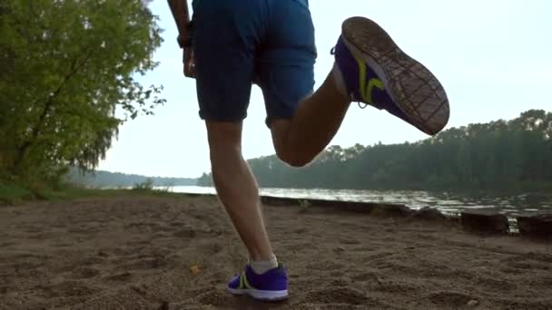 Slow motion video steadicam stóp biegaczy na na mokrym piasku nad brzegiem rzeki, 240 fps — Wideo stockowe