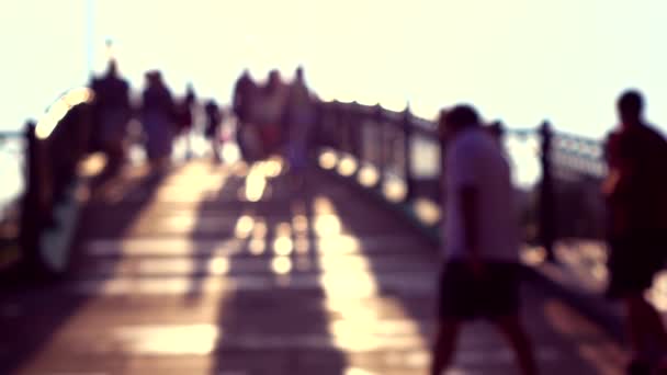 Gente borrosa en el soleado puente arqueado del parque. Super cámara lenta, colores púrpura. 240 fps — Vídeo de stock