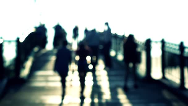 Verschwommene Silhouetten von Männern und Frauen auf sonnigen Bogenbrücken. Super Zeitlupenaufnahme, blaue Farben — Stockvideo