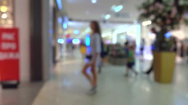 Clientes irreconhecíveis andando no moderno shopping center. 4K bokeh vídeo — Vídeo de Stock