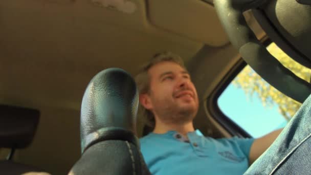 Щасливий водій переміщує ручну палицю. Покласти машину в першу передачу. Відео 4K, низький кут огляду — стокове відео