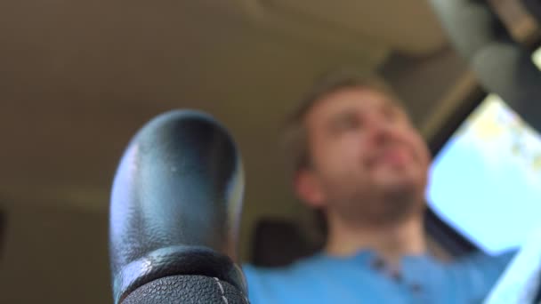 Человек кладет машину в первую ручную передачу. 4K видео, низкоугольный вид — стоковое видео