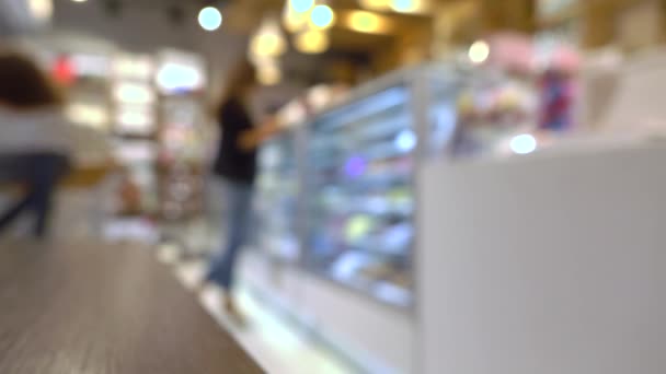 Jeune femme choisissant des chocolats en pâtisserie. 4K fond bokeh vidéo — Video