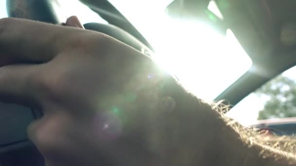 Homme mettant ses mains sur le volant de voiture contre le soleil flamboyant, vidéo 4K — Video