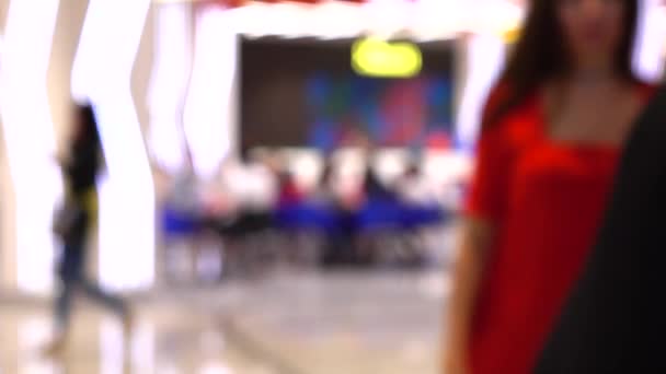 Clientes borrosos caminando en el moderno centro comercial cerca del patio de comidas. 4K fondo bokeh tiro — Vídeo de stock