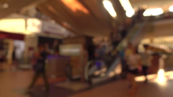 Размытые люди на движущихся лестницах в современном торговом центре. 4K фоновое видео боке — стоковое видео