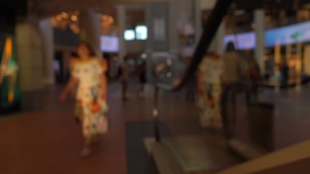 Personas desenfocadas en escaleras móviles en el moderno centro comercial. 4K fondo de vídeo bokeh — Vídeos de Stock