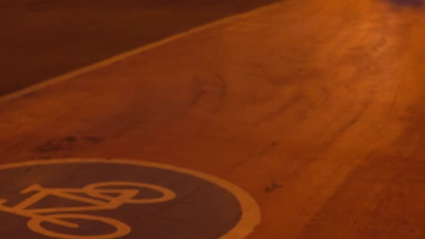 Varias bicicletas que pasan por el carril bici urbano por la noche. Vídeo 4K — Vídeo de stock