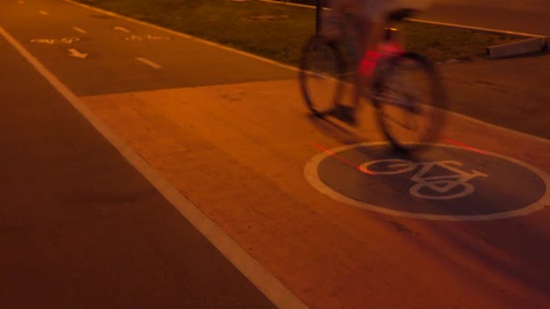 एक साइकिल रात में शहरी बाइक पथ पर से गुजर रहा है। 4K क्लिप — स्टॉक वीडियो